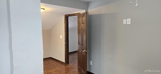 corridor featuring vaulted ceiling and dark wood-type flooring