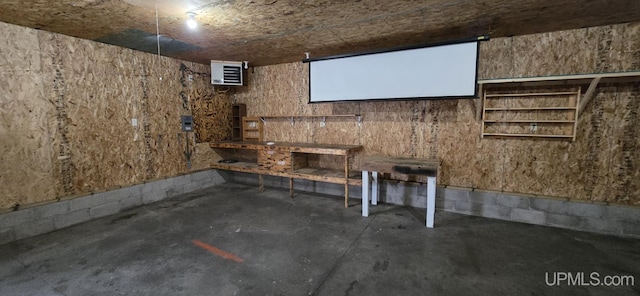 cinema room featuring a workshop area and concrete floors