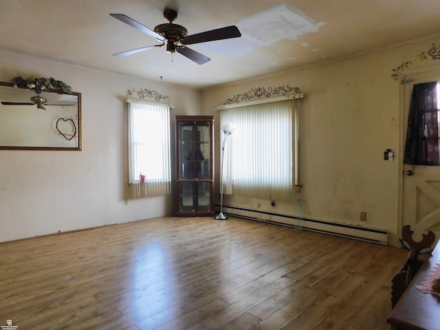 empty room with ceiling fan, wood-type flooring, and baseboard heating