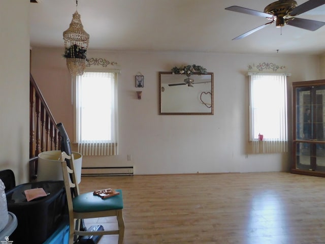 living room with ceiling fan, plenty of natural light, a baseboard radiator, and light hardwood / wood-style floors
