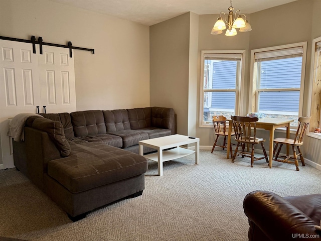 carpeted living room with a barn door and an inviting chandelier