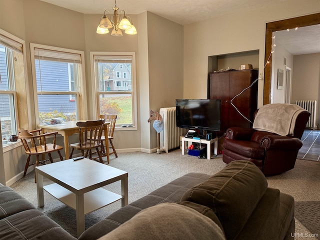 carpeted living room featuring plenty of natural light, radiator heating unit, and an inviting chandelier