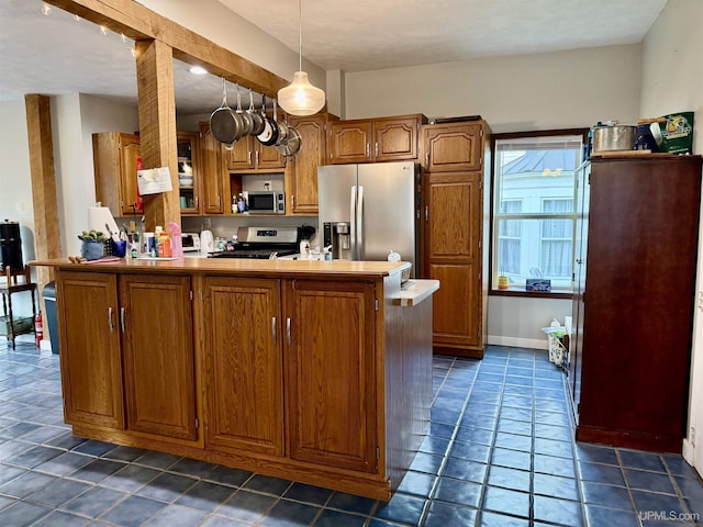 kitchen featuring kitchen peninsula, dark tile patterned floors, stainless steel appliances, and hanging light fixtures