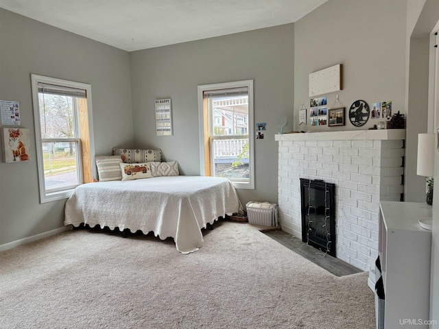 bedroom featuring carpet floors, a fireplace, and multiple windows