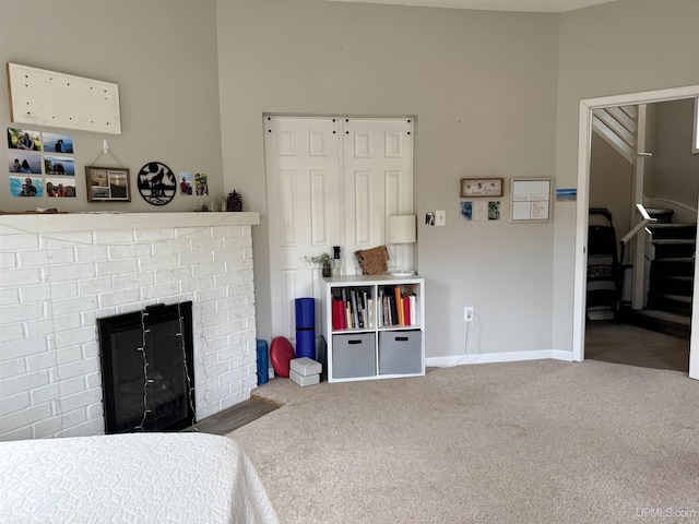 bedroom with carpet flooring and a brick fireplace