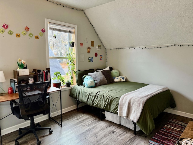 bedroom featuring light wood-type flooring and vaulted ceiling