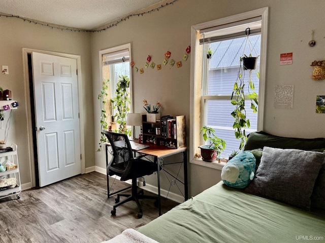 bedroom with light hardwood / wood-style floors and a textured ceiling