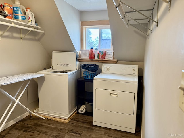 clothes washing area with washing machine and dryer and dark wood-type flooring