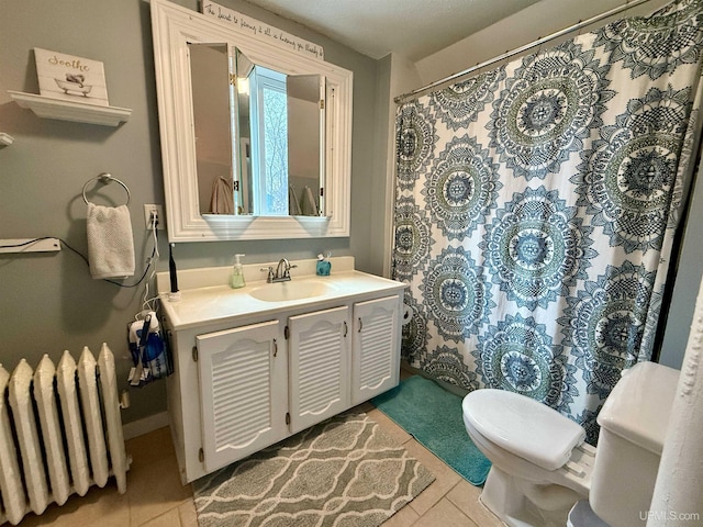 bathroom with tile patterned flooring, vanity, toilet, and radiator