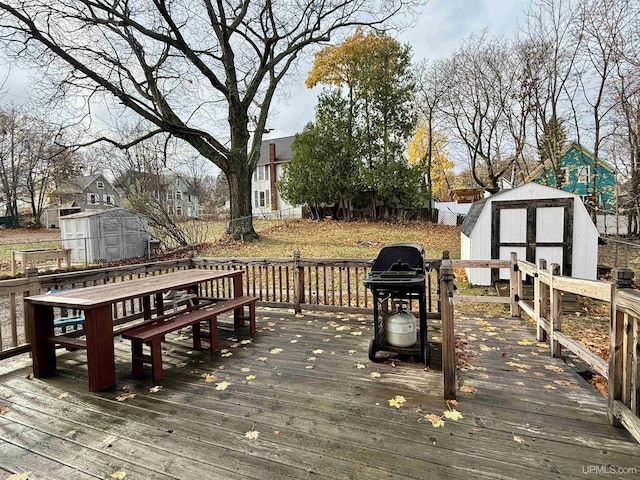 wooden deck featuring a shed and grilling area