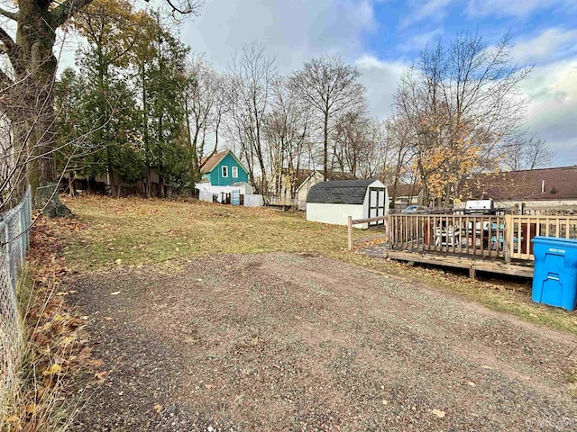 view of yard with a storage unit and a wooden deck