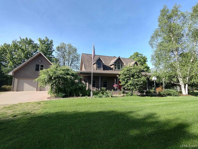 view of front of property with covered porch, a garage, and a front lawn