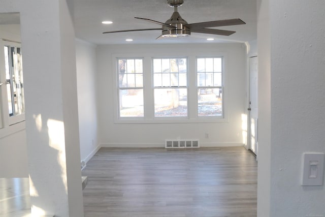 empty room with ceiling fan, wood-type flooring, and crown molding