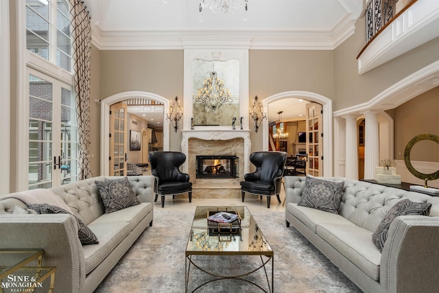 living room with ornamental molding, a high ceiling, and french doors