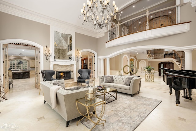 tiled living room with decorative columns, a towering ceiling, and ornamental molding