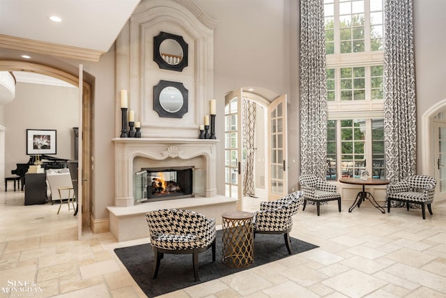 interior space with a multi sided fireplace, ornamental molding, and a towering ceiling