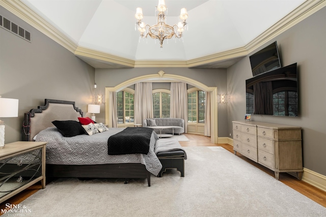 bedroom featuring vaulted ceiling, light hardwood / wood-style floors, ornamental molding, and an inviting chandelier