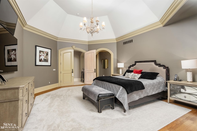 bedroom with crown molding, light hardwood / wood-style flooring, vaulted ceiling, and an inviting chandelier