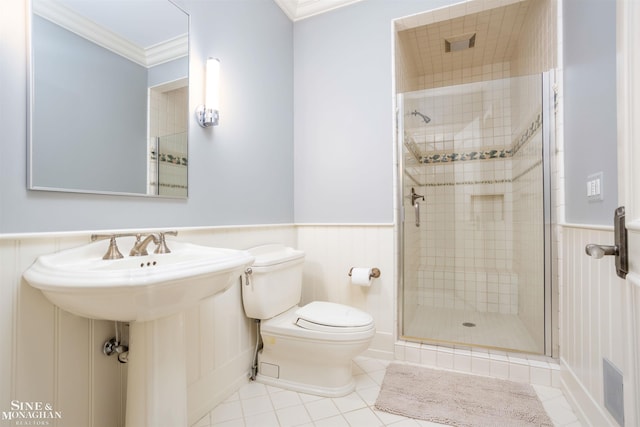 bathroom with tile patterned floors, toilet, walk in shower, and crown molding