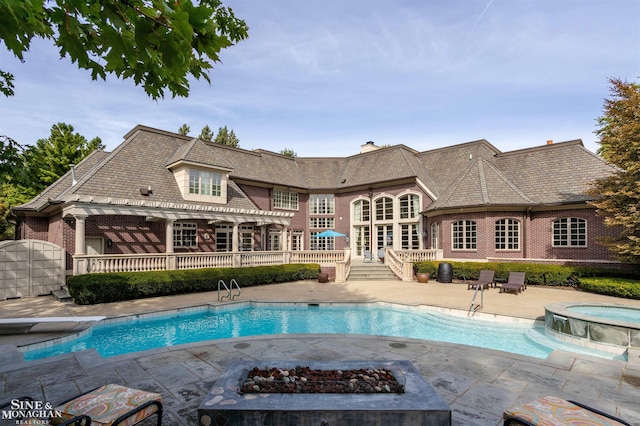 back of house featuring french doors, a patio, a fire pit, and a pool with hot tub