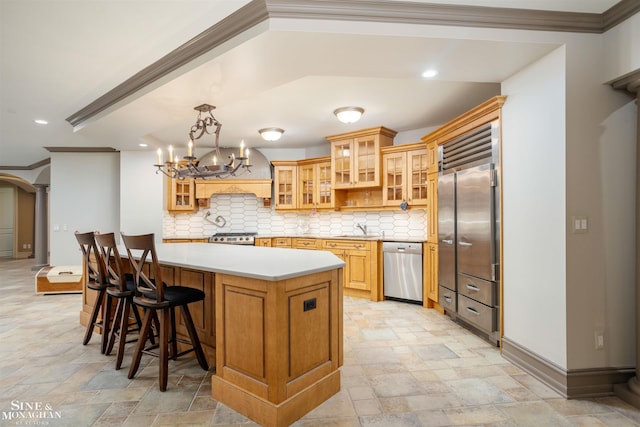 kitchen with ornamental molding, hanging light fixtures, appliances with stainless steel finishes, and tasteful backsplash