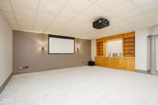 home theater with carpet, a paneled ceiling, and built in features