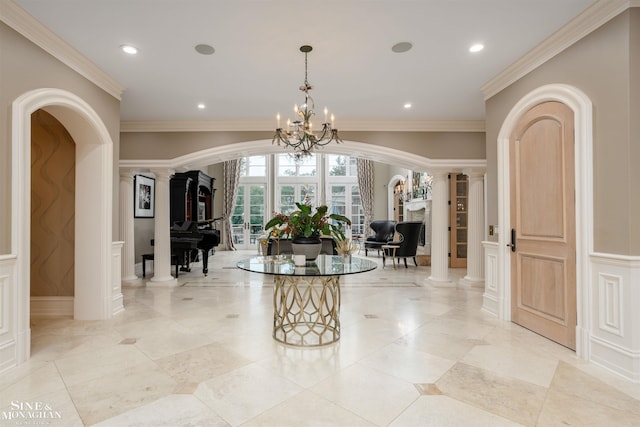 interior space with ornate columns, crown molding, and a chandelier