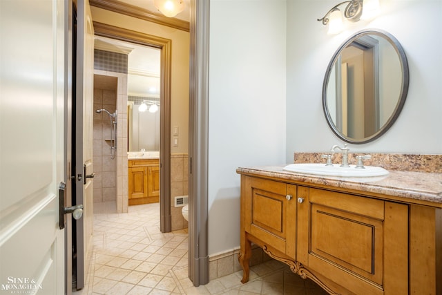 bathroom featuring tile patterned floors, ornamental molding, vanity, tiled shower, and toilet