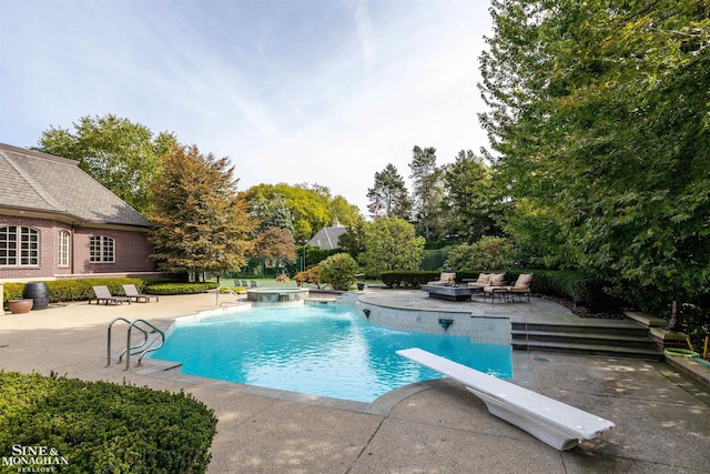 view of swimming pool with a hot tub, a diving board, and a patio area