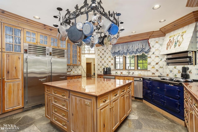 kitchen featuring a center island, backsplash, sink, light stone countertops, and stainless steel appliances