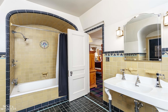 bathroom with tile patterned flooring, shower / bath combo, and tile walls