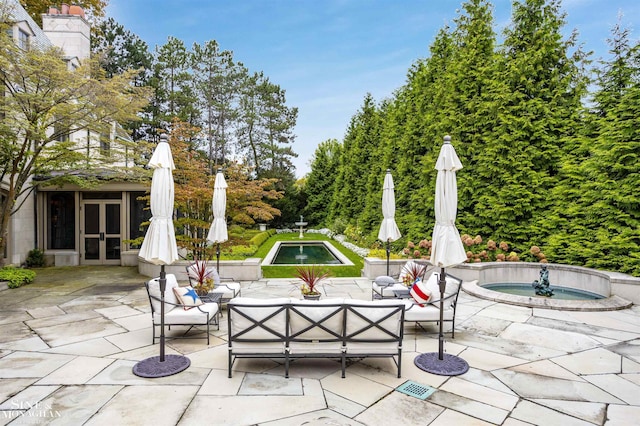 view of patio / terrace with an outdoor hangout area, an in ground hot tub, and french doors