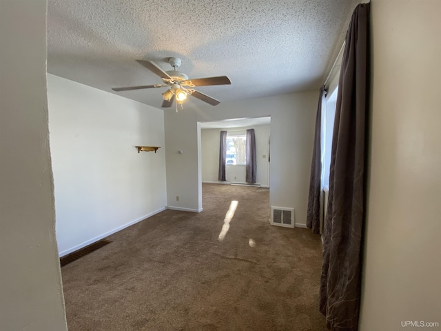 carpeted empty room featuring ceiling fan and a textured ceiling