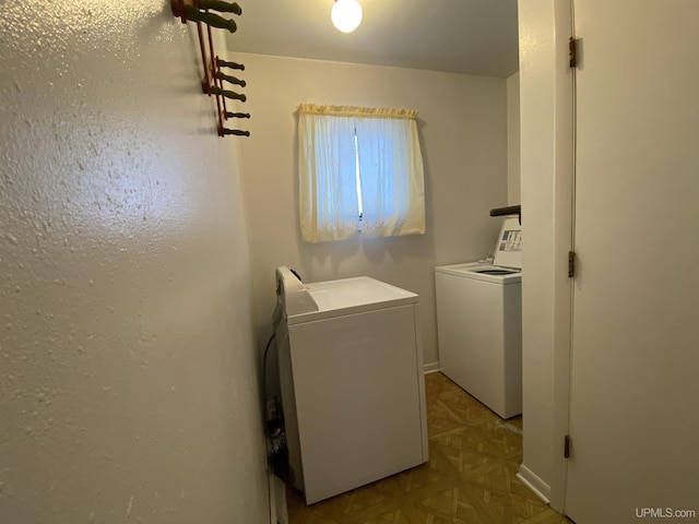 clothes washing area with light parquet floors and washing machine and clothes dryer