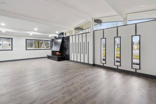 unfurnished living room featuring lofted ceiling with beams and hardwood / wood-style flooring