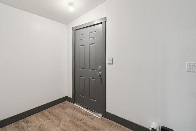 interior space featuring light wood-type flooring and vaulted ceiling