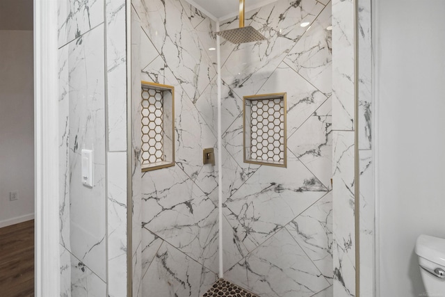 bathroom featuring toilet and tiled shower