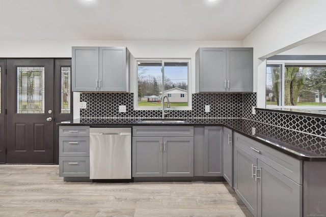 kitchen with gray cabinets, stainless steel dishwasher, light hardwood / wood-style floors, and sink