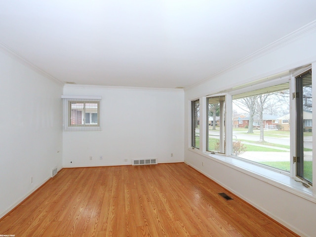 unfurnished room with light wood-type flooring, plenty of natural light, and ornamental molding