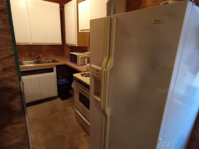 kitchen featuring sink, white cabinets, and white appliances