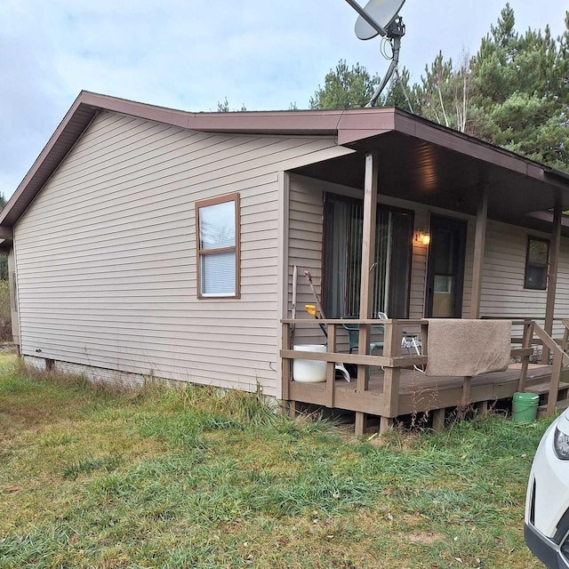 back of house featuring a wooden deck and a yard