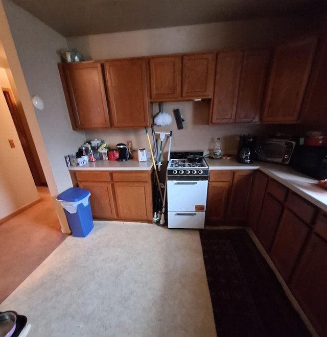 kitchen with light carpet and white range with gas stovetop