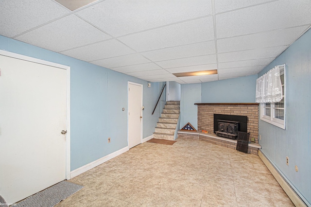 interior space with a drop ceiling and a baseboard radiator