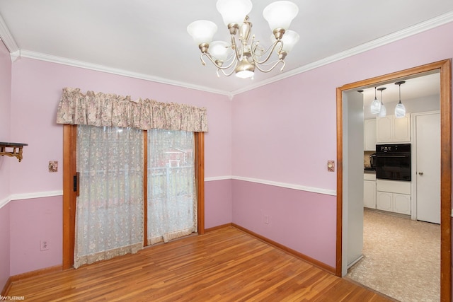 unfurnished dining area with ornamental molding, light hardwood / wood-style flooring, and an inviting chandelier