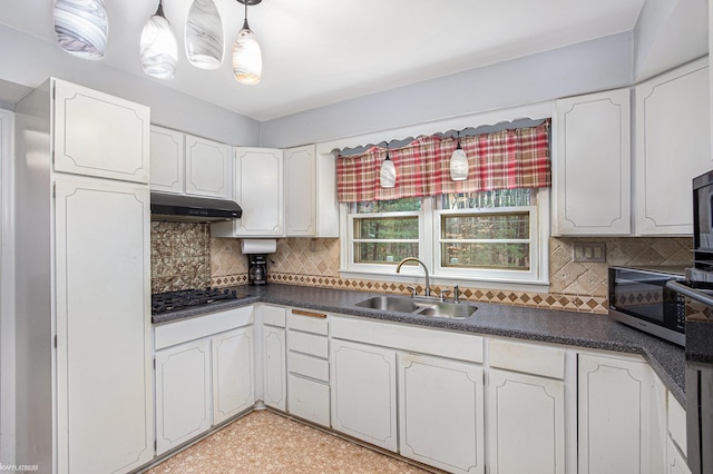 kitchen featuring white cabinets, sink, gas cooktop, and tasteful backsplash