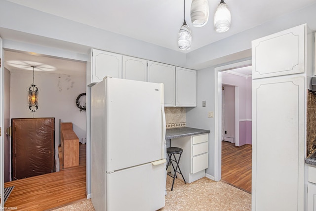 kitchen featuring backsplash, light hardwood / wood-style floors, decorative light fixtures, white fridge, and white cabinetry