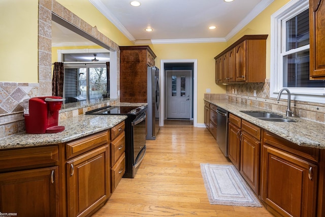 kitchen featuring sink, crown molding, light wood-type flooring, appliances with stainless steel finishes, and decorative backsplash