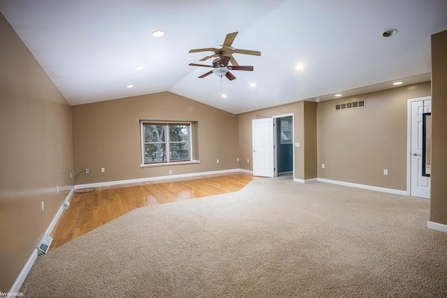 carpeted spare room with lofted ceiling and ceiling fan