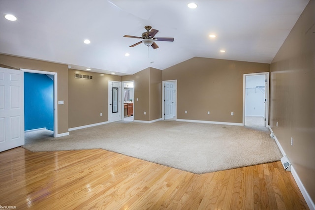 unfurnished living room with light hardwood / wood-style flooring, vaulted ceiling, and ceiling fan