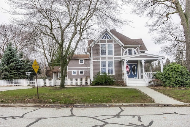 victorian-style house with a front lawn and a porch